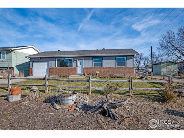 a view of a house with a yard and wooden fence