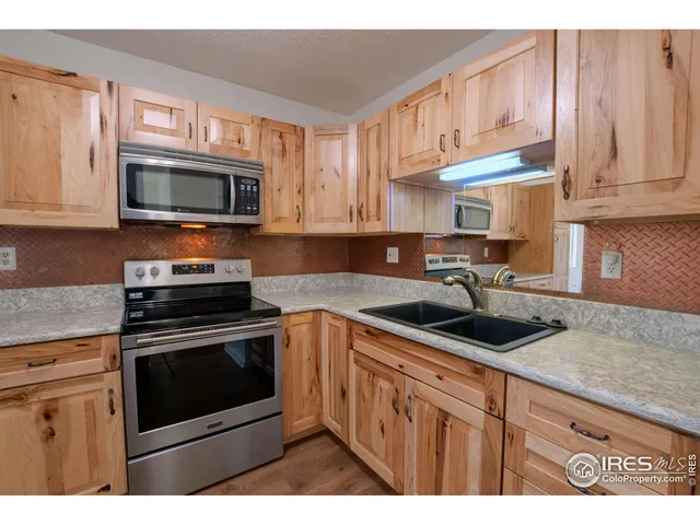 a kitchen with stainless steel appliances granite countertop a sink stove microwave and cabinets