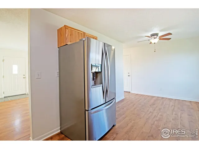 a view of kitchen with stainless steel appliances refrigerator and wooden floor