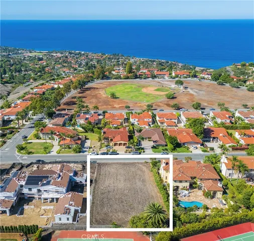 an aerial view of residential houses with outdoor space and ocean view