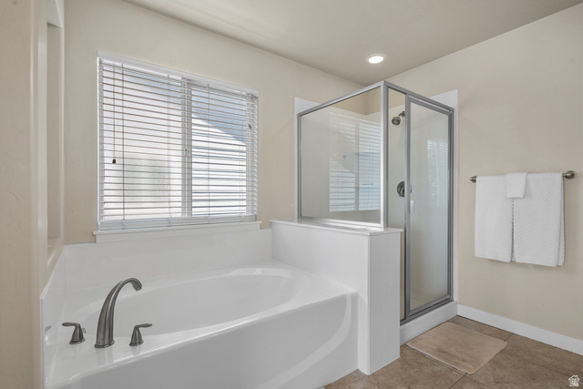 955 Delorean Lane Midvale, UT 84047 - Photo 19 of 47 Soaking tub with brushed nickel fixtures, a glass-enclosed shower, a window with blinds, recessed lighting, and tile flooring