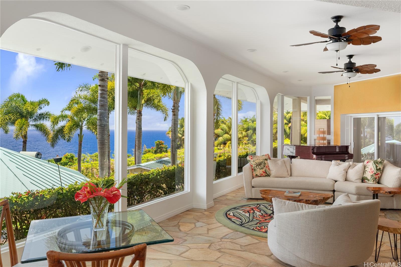 31-212 Hawaii Belt Road Hakalau, HI 96710 - Photo 5 of 25 Elegant, oversized windows unveil a vivid tapestry of lush tropical landscaping and serene ocean views, blurring the line between indoor comfort and island beauty