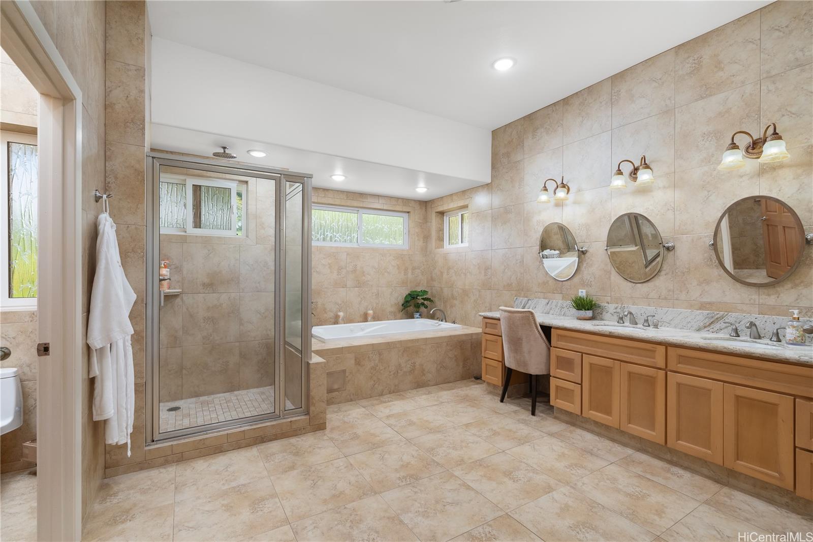 31-212 Hawaii Belt Road Hakalau, HI 96710 - Photo 9 of 25 Primary bathroom featuring a luxurious full tub, glass shower, double sinks, and a sleek vanity area. A massive adjoining room, originally designed as an office, now serves as an expansive walk-in closet