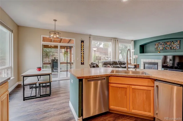 a kitchen with stainless steel appliances granite countertop a sink and wooden floor