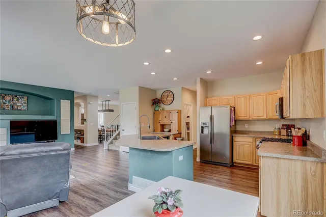 a kitchen with stainless steel appliances kitchen island granite countertop a refrigerator and microwave