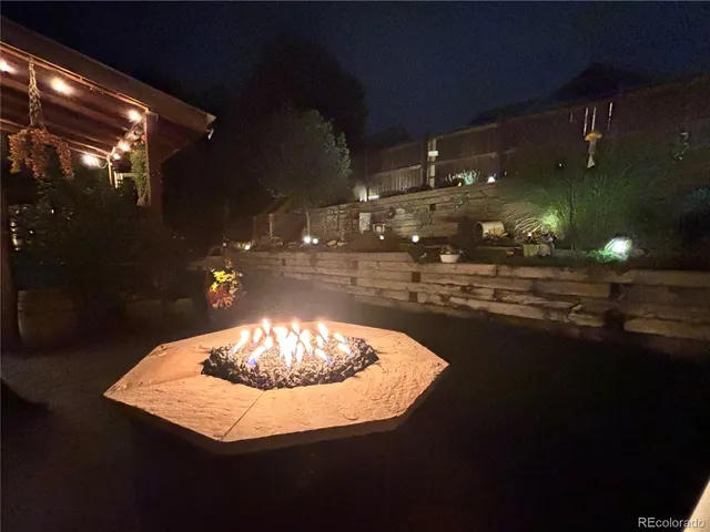 a roof deck with table and chairs and potted plants