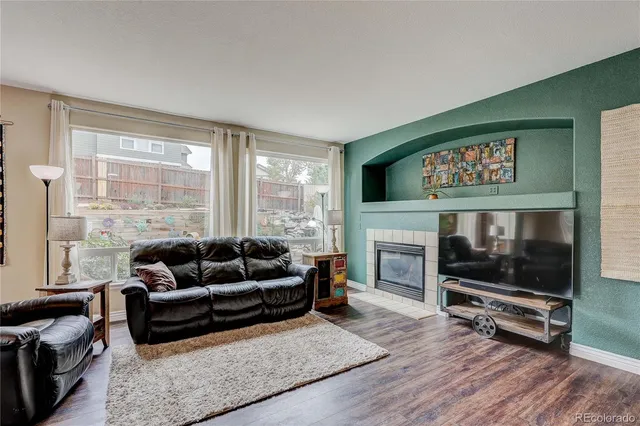 a living room with furniture a flat screen tv and a fireplace