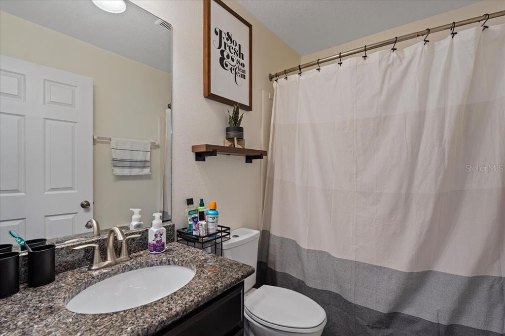 3271 Titanic Circle, Unit 39 Indialantic, FL 32903 - Photo 25 of 60 a bathroom with a granite countertop sink toilet a mirror and shower curtain