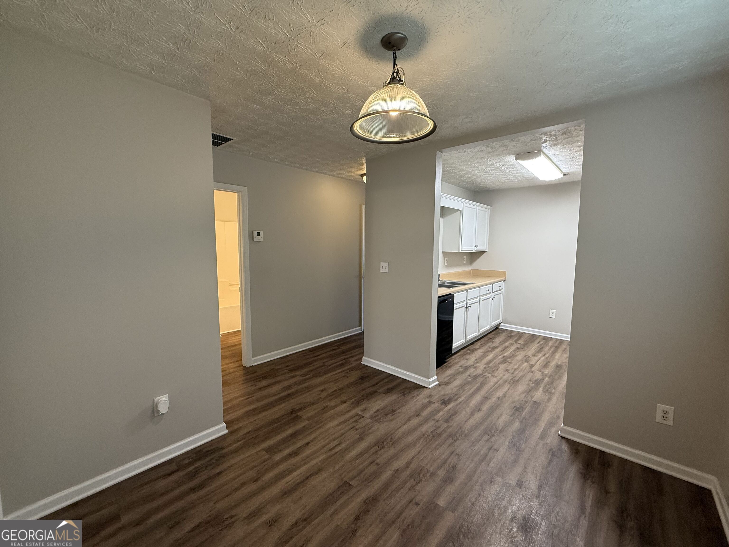 6132 Ruth Street Southwest Covington, GA 30014 - Photo 8 of 33 a view of a room with wooden floor and kitchen