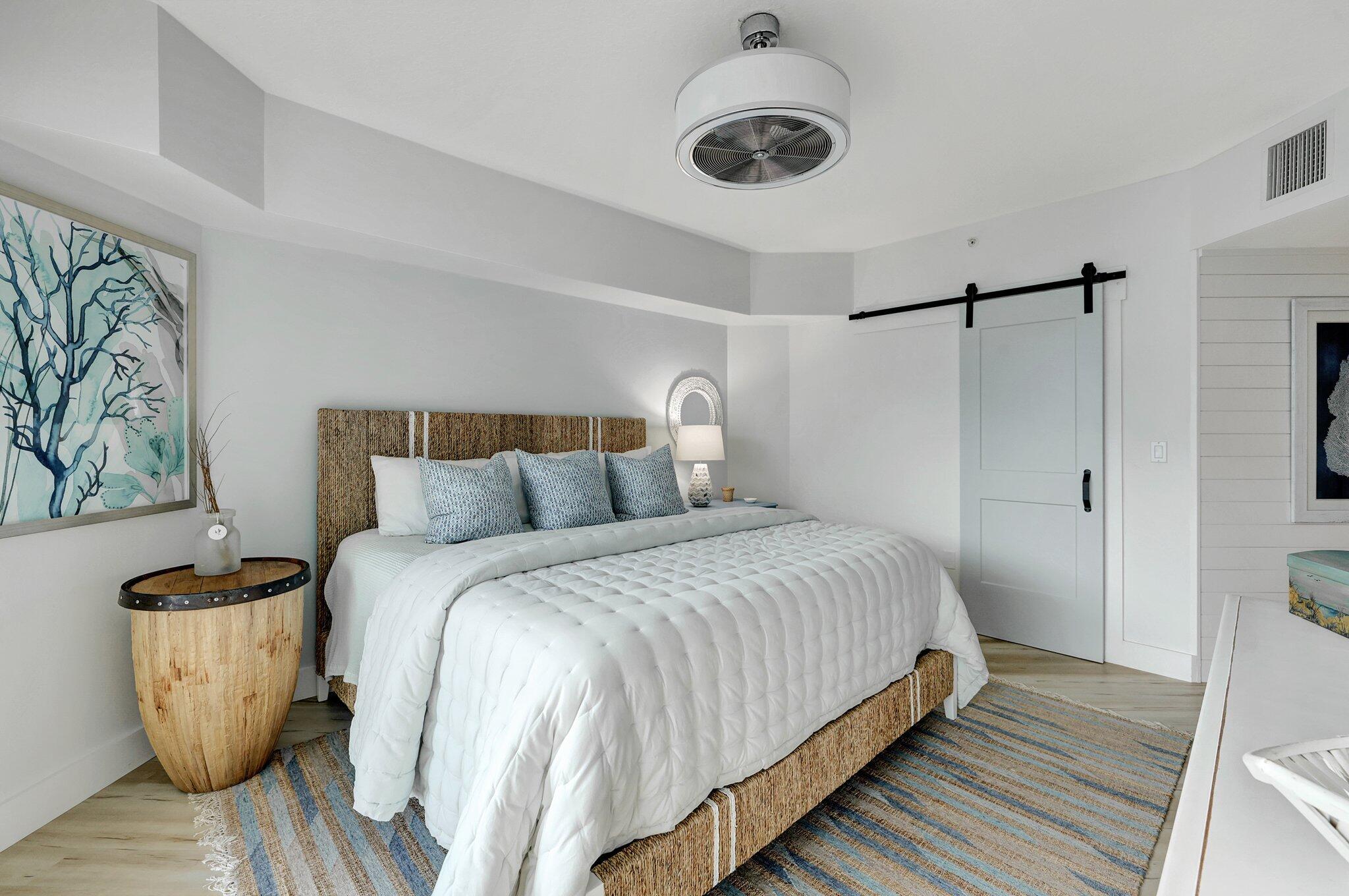 875 Northwest Flagler Avenue, Unit 404 Stuart, FL 34994 - Photo 16 of 56 a bedroom with a bed and a chandelier