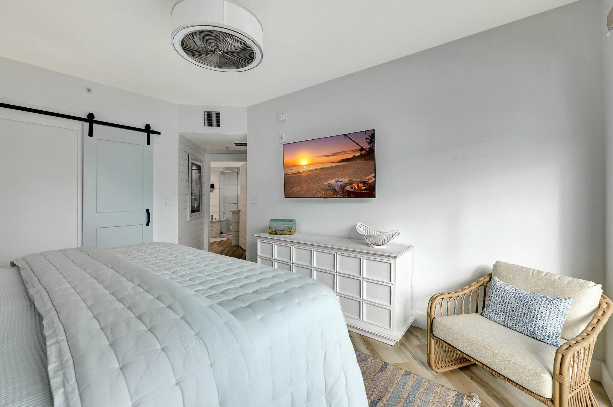 875 Northwest Flagler Avenue, Unit 404 Stuart, FL 34994 - Photo 17 of 56 a bedroom with a bed and a television