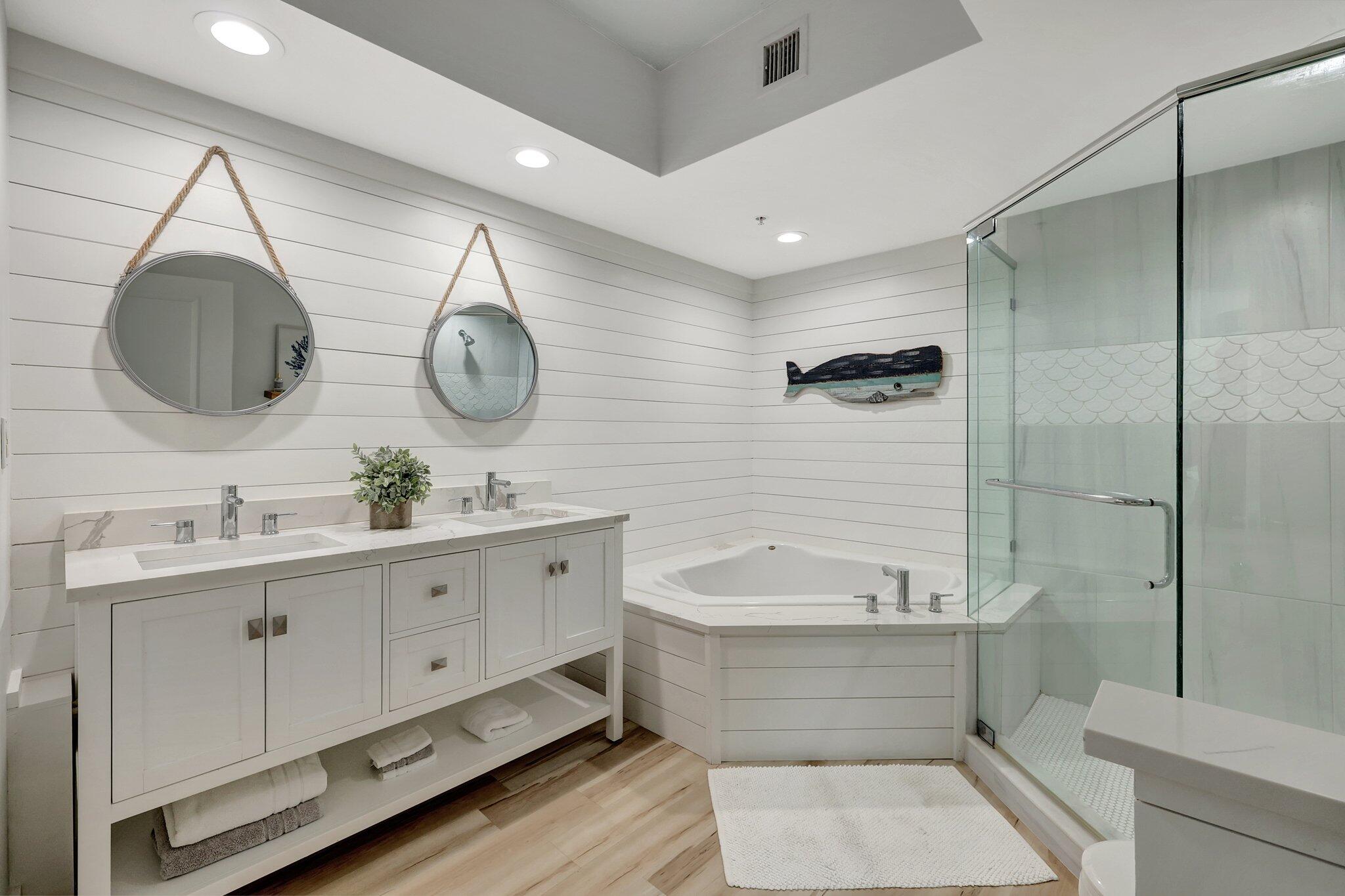 875 Northwest Flagler Avenue, Unit 404 Stuart, FL 34994 - Photo 18 of 56 a bathroom with a double vanity sink mirror and bathtub