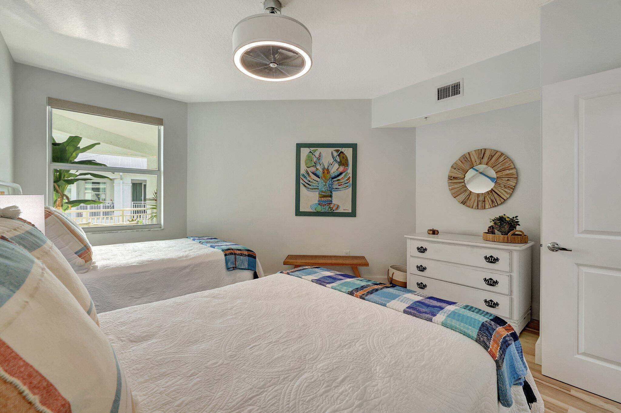 875 Northwest Flagler Avenue, Unit 404 Stuart, FL 34994 - Photo 21 of 56 a bedroom with a bed and a chandelier