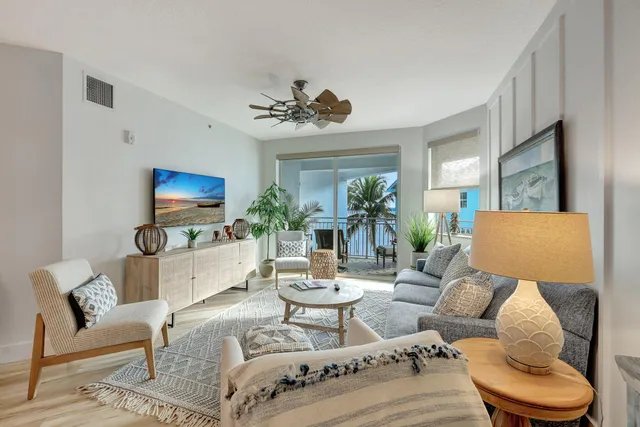 a living room with furniture a flat screen tv and a large window