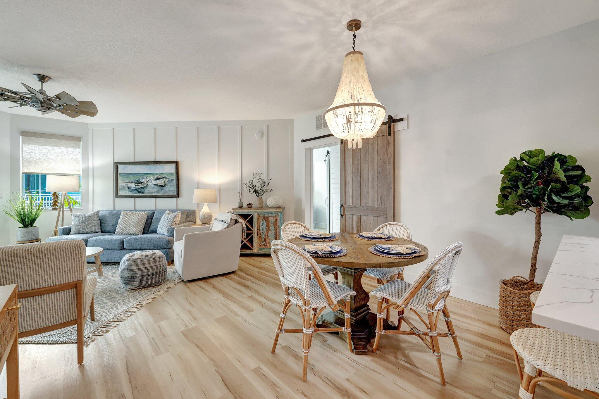875 Northwest Flagler Avenue, Unit 404 Stuart, FL 34994 - Photo 5 of 56 a living room with furniture a dining table and a chandelier
