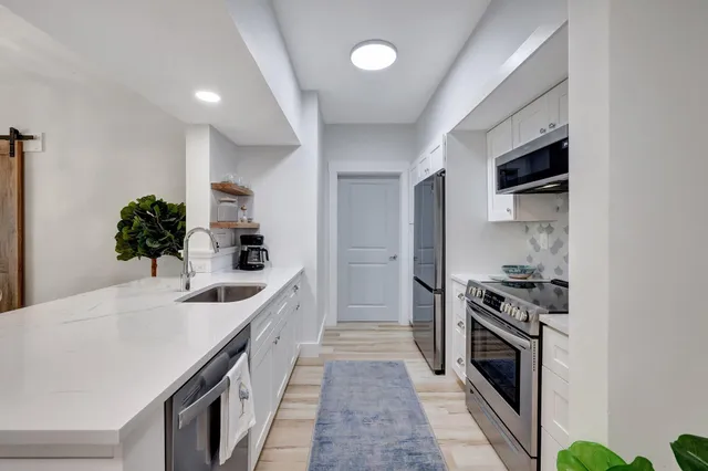a kitchen with granite countertop a sink and stainless steel appliances