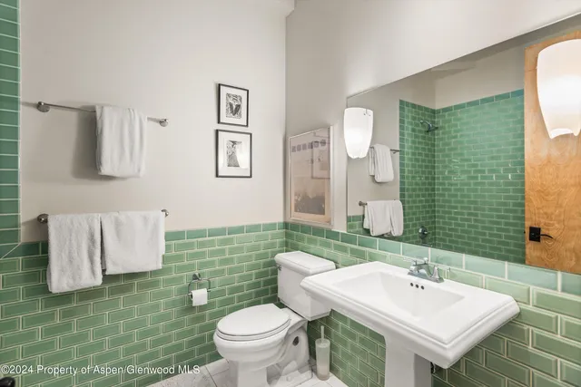 a bathroom with a sink toilet and mirror