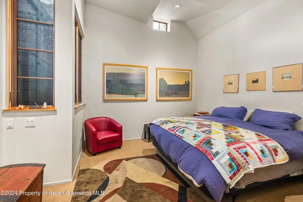 a bedroom with two beds and painting on the wall