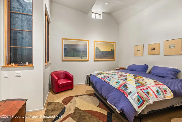 a bedroom with two beds and painting on the wall