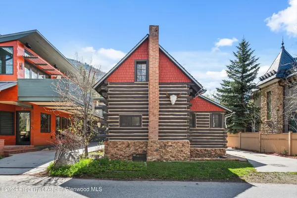 a view of a house with a yard and table and chair under an umbrella
