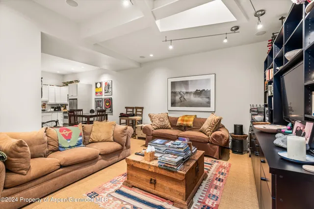 a living room with furniture a rug and a flat screen tv