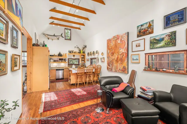 a living room with furniture a rug and a wall painting