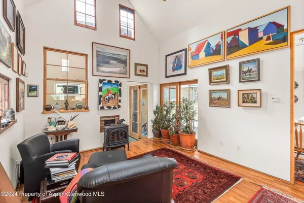 a living room with patio furniture and a painting on the wall
