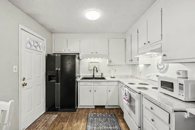 a living room with furniture and a refrigerator