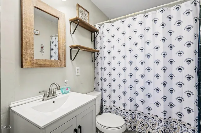 a bathroom with a sink toilet and mirror
