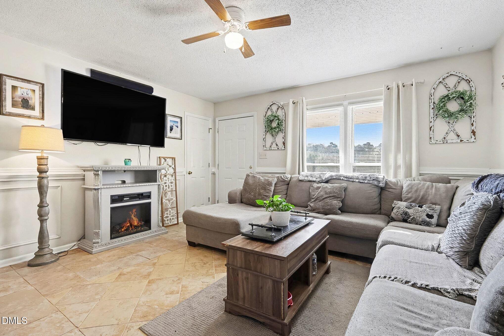 104 Rosebud Street Spring Lake, NC 28390 - Photo 5 of 29 a living room with furniture a flat screen tv and a fireplace