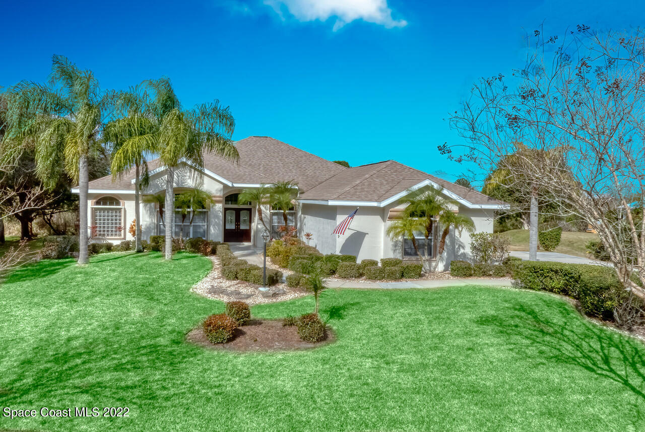 4099 Sparrow Hawk Road Melbourne, FL 32934 - Photo 1 of 48 a front view of a house with a yard table and chairs
