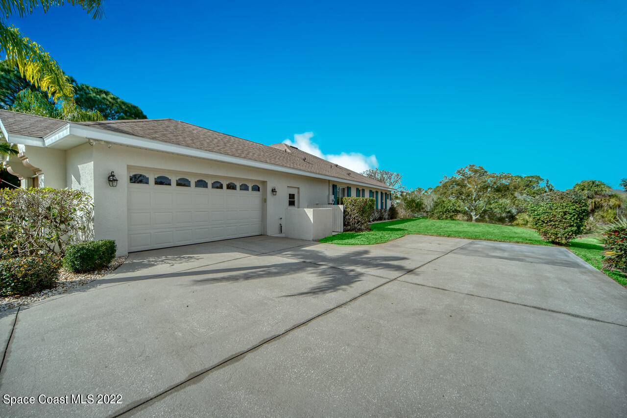 4099 Sparrow Hawk Road Melbourne, FL 32934 - Photo 18 of 48 a front view of a house with a yard and garage