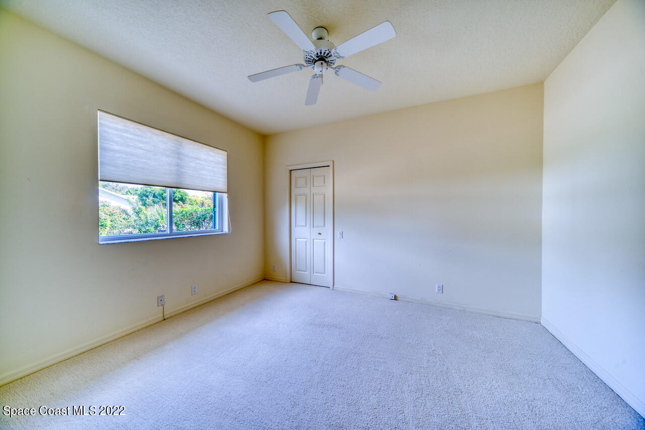 4099 Sparrow Hawk Road Melbourne, FL 32934 - Photo 32 of 48 an empty room with windows and ceiling fan
