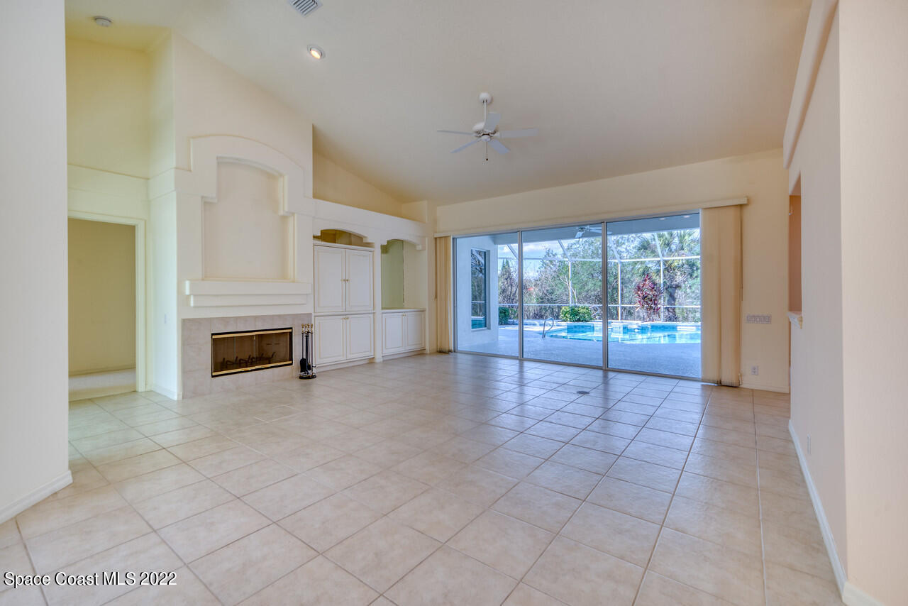 4099 Sparrow Hawk Road Melbourne, FL 32934 - Photo 5 of 48 a view of an empty room with a fireplace and a window