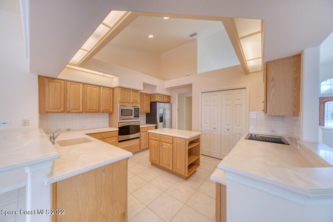 4099 Sparrow Hawk Road Melbourne, FL 32934 - Photo 8 of 48 a kitchen that has a sink and a stove in it