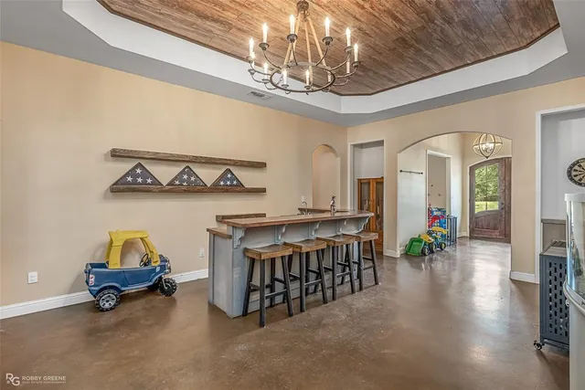 a living room with stainless steel appliances furniture and a chandelier