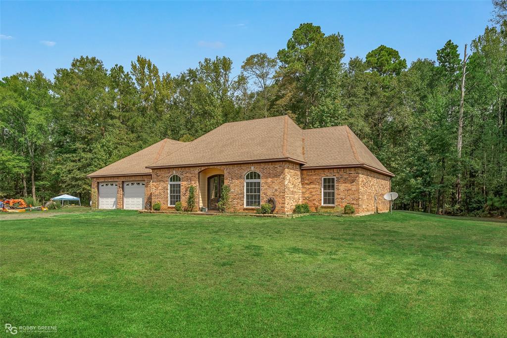 495 John Gloster, LA 71030 - Photo 2 of 40 a white house with a yard and trees in the background