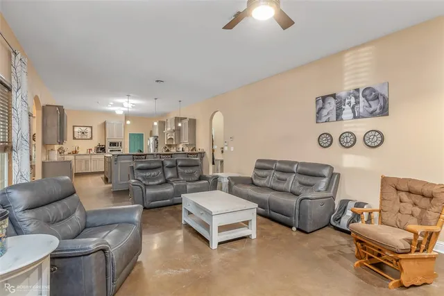 a living room with furniture and a view of kitchen