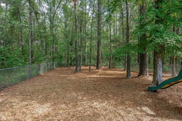 a view of a lake with a yard and large trees