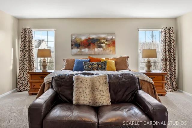 a bedroom with a large bed couch and a window