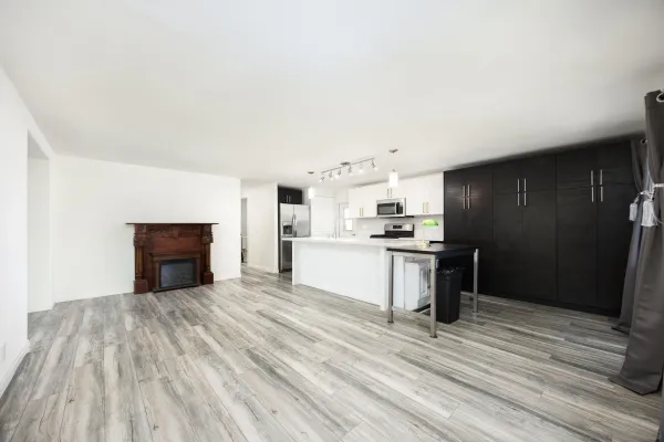 a view of kitchen with granite countertop cabinets and refrigerator