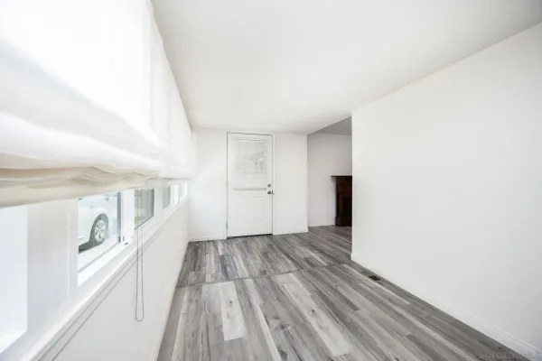 a view of an empty room with wooden floor