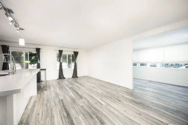 a view of empty room with wooden floor