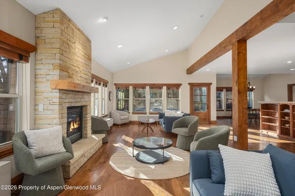 a living room with furniture fireplace and a large window