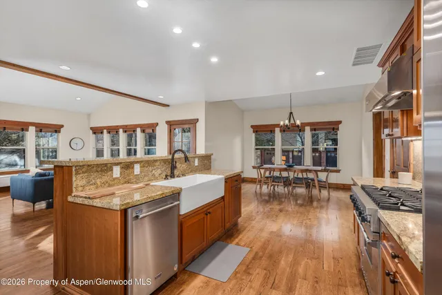 a kitchen with stainless steel appliances granite countertop a stove and a wooden floors