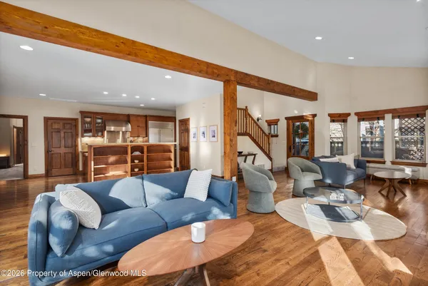 a living room with furniture kitchen view and large windows