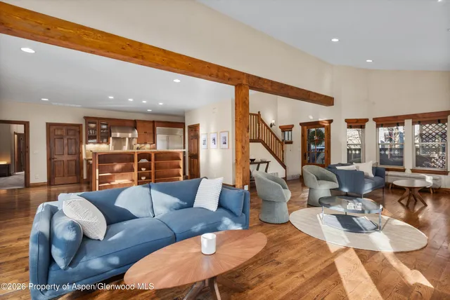 a living room with furniture kitchen view and large windows