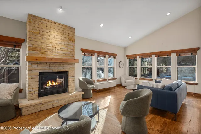 a living room with furniture a fireplace and a large window