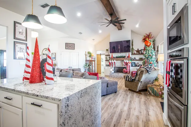 a bathroom with a granite countertop sink a toilet and a shower curtain