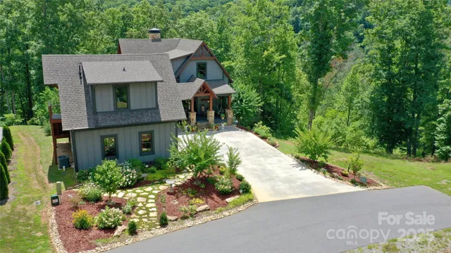 an aerial view of a house with a yard and large trees